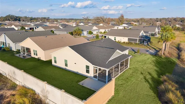 an aerial view of residential houses with outdoor space and trees