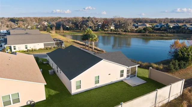 an aerial view of house with yard and lake view