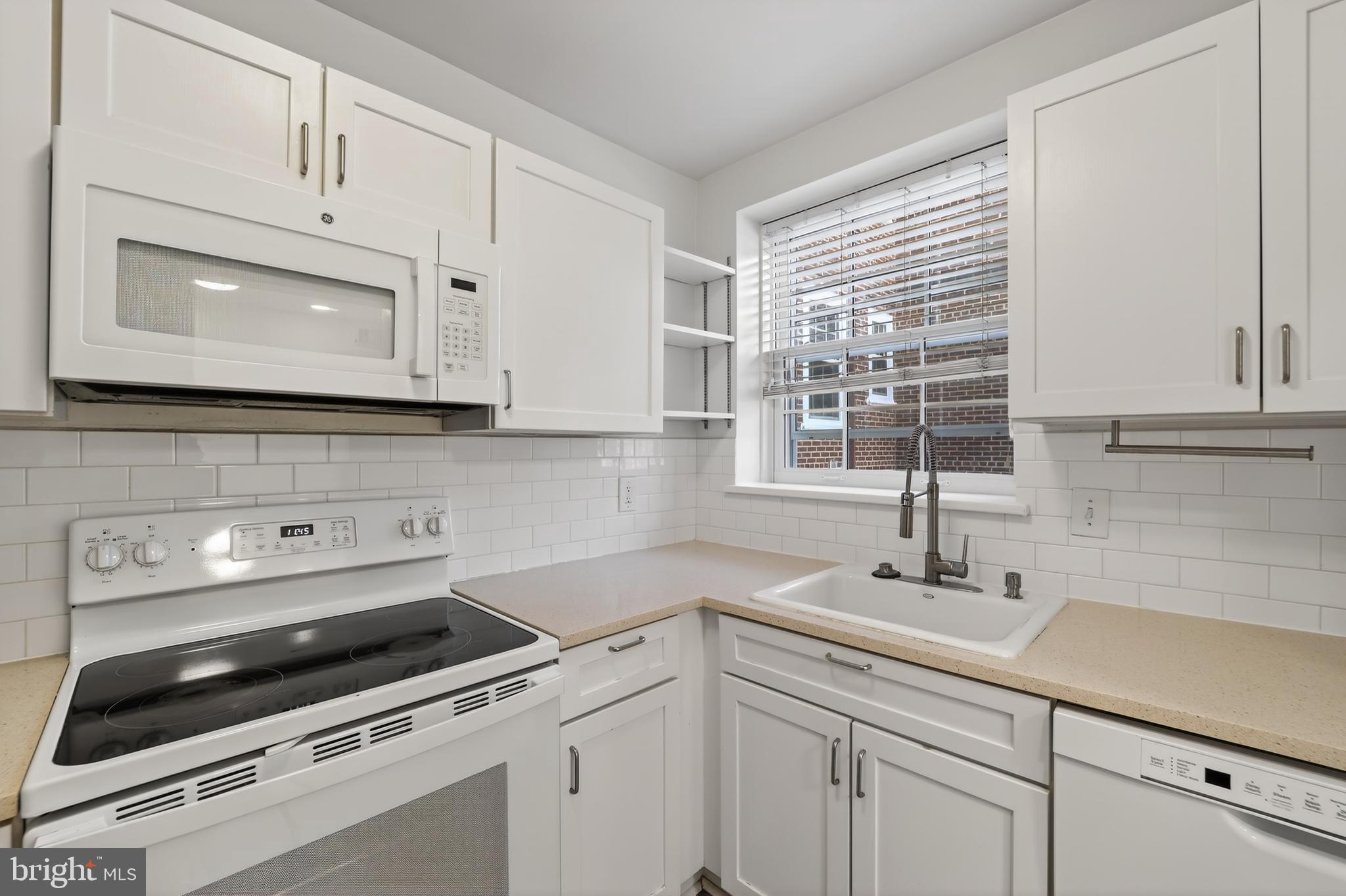 3450 39th Street Northwest, Unit A685 Washington, DC 20016 - Photo 7 of 30 a kitchen with white cabinets appliances and a sink