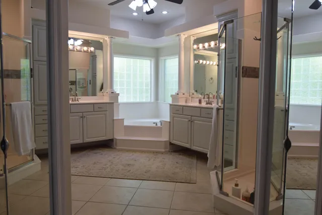 a bathroom with a tub sink shower and mirror
