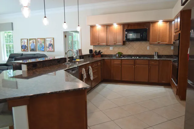 a kitchen with stainless steel appliances granite countertop a sink a stove counter space and cabinets