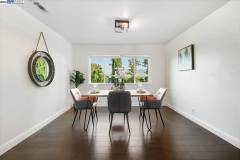 a dining room with furniture a window and wooden floor