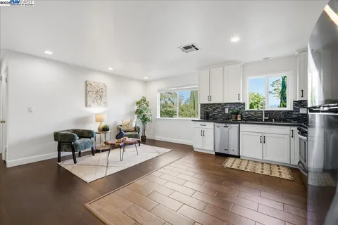a kitchen with granite countertop a stove and white cabinets