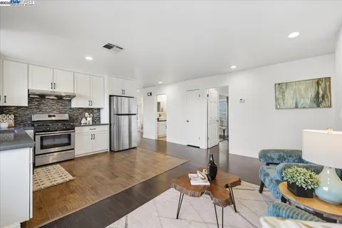 a kitchen with stainless steel appliances granite countertop a refrigerator and a stove top oven