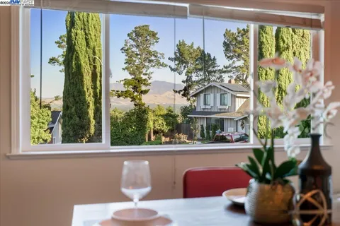 a vase of flowers sitting on a table with a window