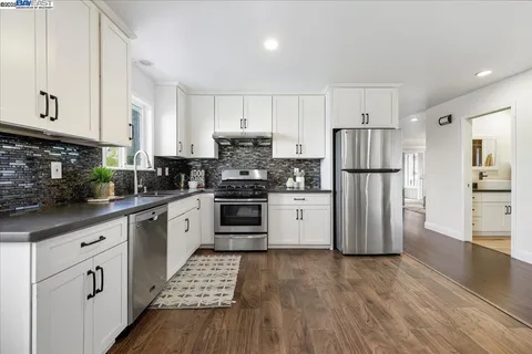 a kitchen with white cabinets and white appliances
