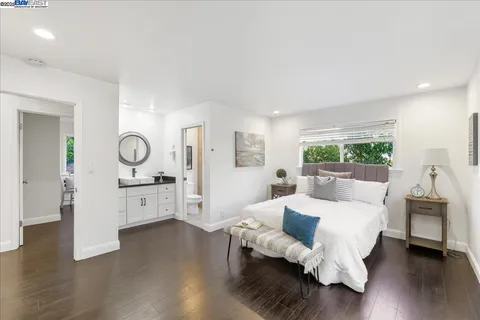 a spacious bedroom with a bed and a chair