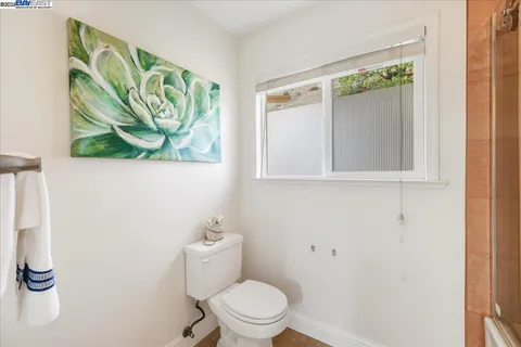a view of a hallway with wooden floor and a kitchen space