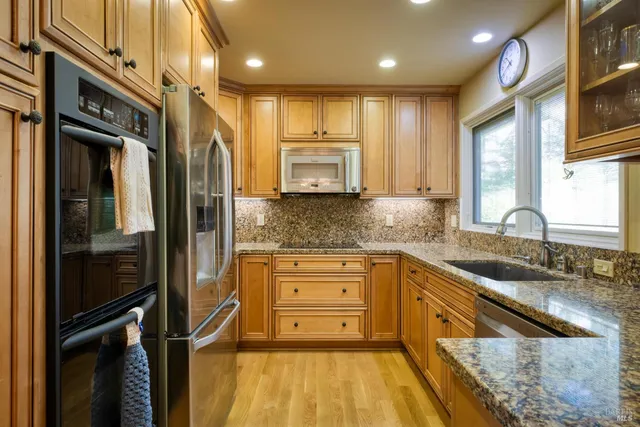 a kitchen with granite countertop a refrigerator and a sink
