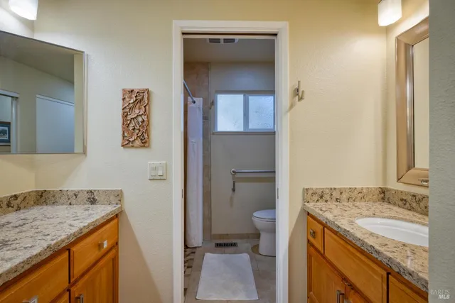 a bathroom with a granite countertop sink and a mirror