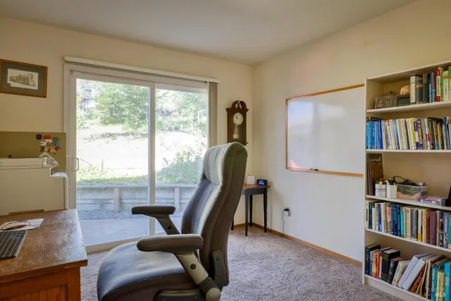 a view of a workspace with furniture and a bookshelf