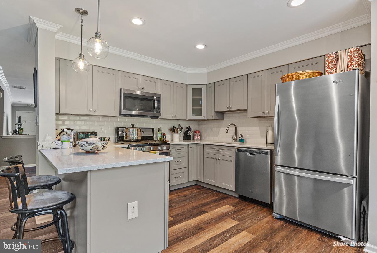 62 Stokes Road Mount Laurel, NJ 08054 - Photo 2 of 10 a kitchen with a refrigerator a microwave oven a sink dishwasher and white cabinets with wooden floor