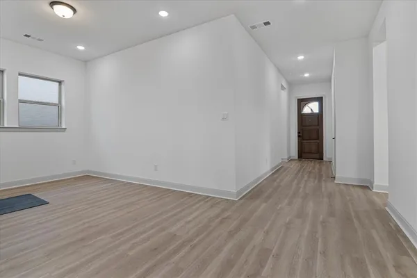 a view of empty room with wooden floor