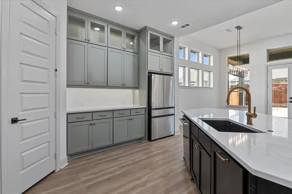 a kitchen with kitchen island white cabinets and refrigerator