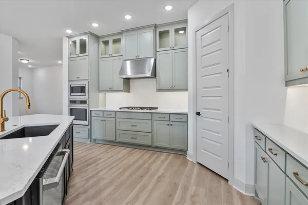 a kitchen with kitchen island white cabinets and refrigerator