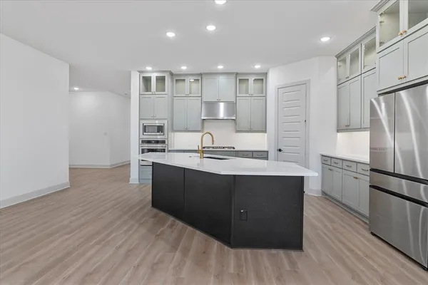 a view of kitchen with stainless steel appliances kitchen island granite countertop a stove and a sink