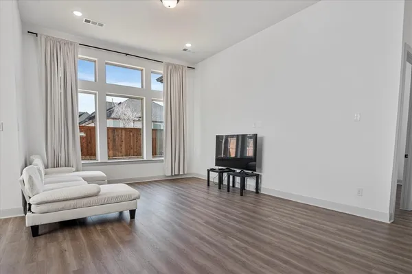 a living room with furniture and a wooden floor