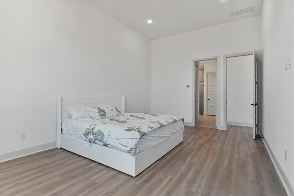 a view of a bedroom with wooden floor