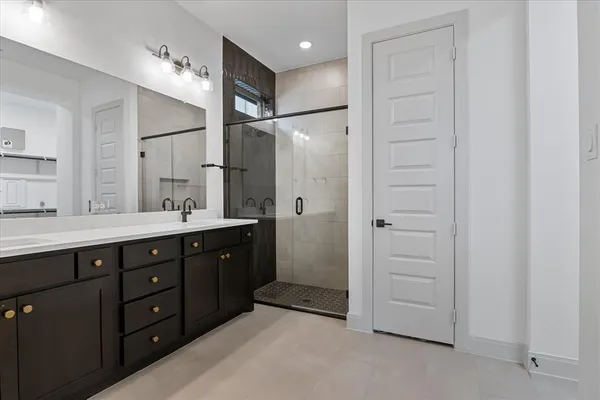 a bathroom with a double vanity sink a large mirror and shower