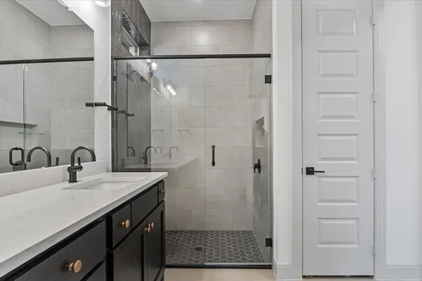 a bathroom with a shower sink and mirror