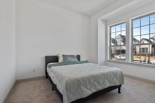 a large bed sitting in a bedroom next to a window