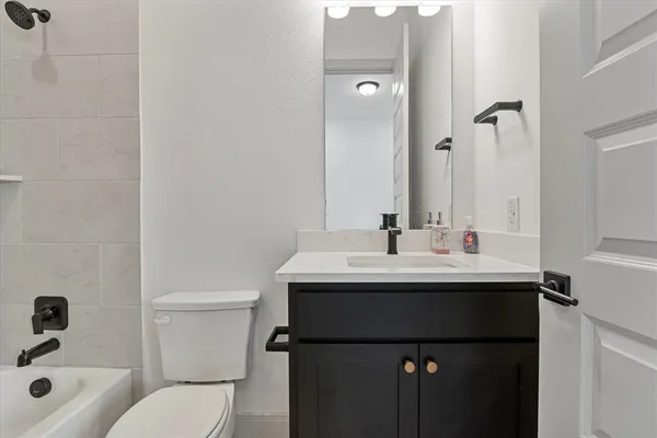 a bathroom with a sink toilet vanity and shower
