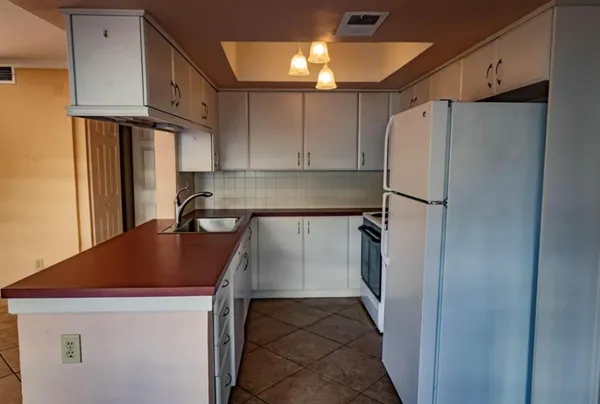 a kitchen with a refrigerator a sink and cabinets