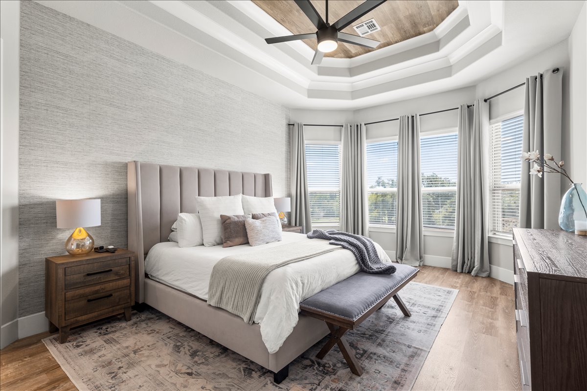 200 Draco Street Georgetown, TX 78628 - Photo 12 of 39 a bedroom with a large bed and a chandelier