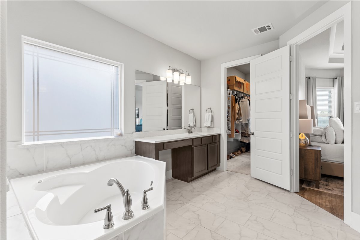 200 Draco Street Georgetown, TX 78628 - Photo 15 of 39 a bathroom with a tub a sink and a mirror