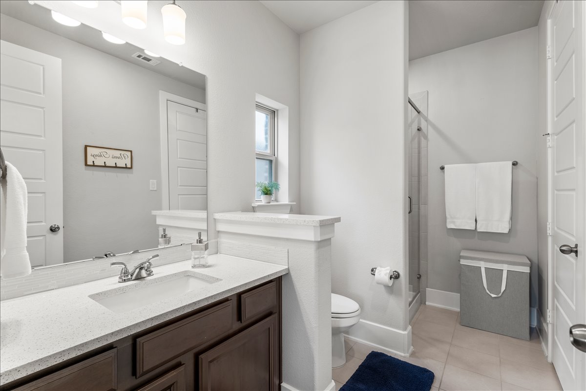 200 Draco Street Georgetown, TX 78628 - Photo 18 of 39 a bathroom with a sink toilet a mirror and shower