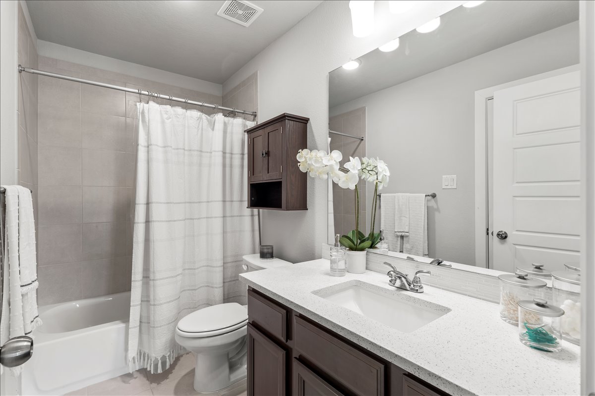 200 Draco Street Georgetown, TX 78628 - Photo 25 of 39 a bathroom with a granite countertop sink toilet and shower