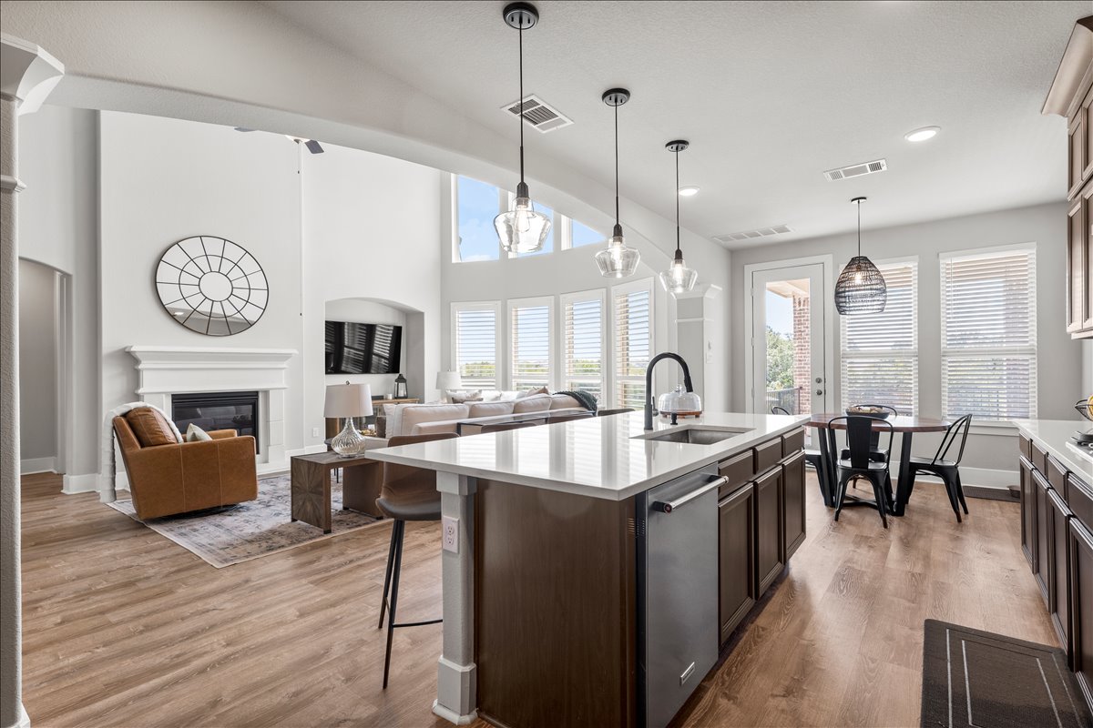 200 Draco Street Georgetown, TX 78628 - Photo 38 of 39 a large kitchen with stainless steel appliances a stove center island with a dining table and chairs