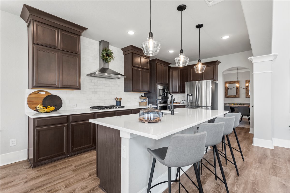 200 Draco Street Georgetown, TX 78628 - Photo 9 of 39 a kitchen with a dining table chairs sink and cabinets