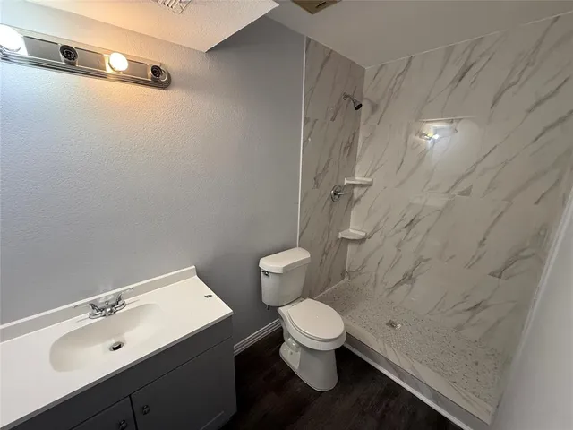 a walk in closet with wooden floor and a sink