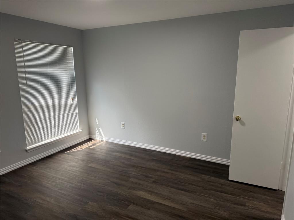 12482 Abrams Road, Unit 1427 Dallas, TX 75243 - Photo 9 of 10 a view of an empty room with wooden floor and a window