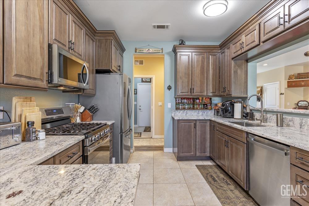 Undisclosed Address Tehachapi, CA 93561 - Photo 9 of 29 a kitchen with stainless steel appliances granite countertop a stove a sink and a microwave
