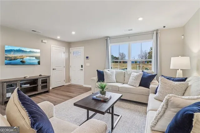 a kitchen with kitchen island granite countertop wooden floors and white cabinets
