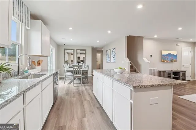a kitchen with white cabinets stainless steel appliances and a center island