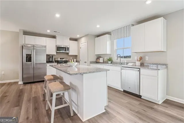 a kitchen with granite countertop kitchen island wooden cabinets and stainless steel appliances
