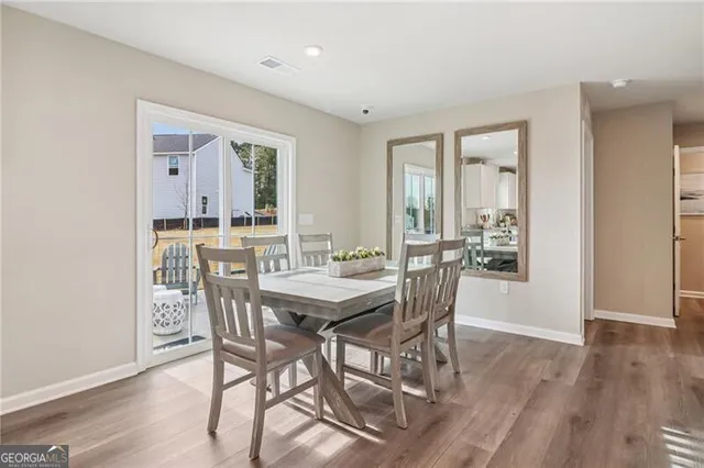 a dining room with stainless steel appliances a dining table chairs and view kitchen
