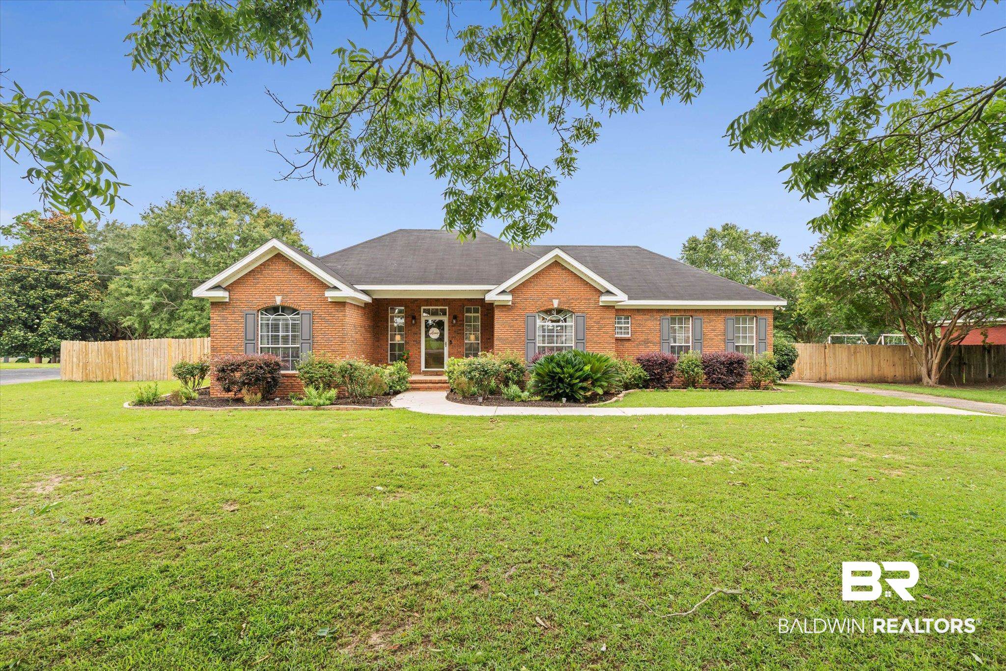 3170 Scott Dairy Loop Road West Mobile, AL 36695 - Photo 23 of 24 Brick ranch-style residence featuring a dark shingle roof, arched entryway, and decorative window shutters
