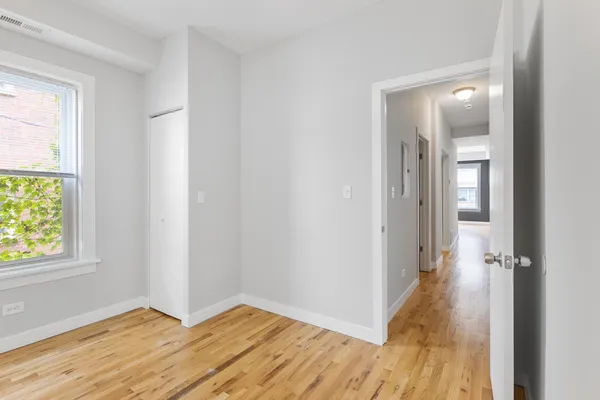 an empty room with windows and closet