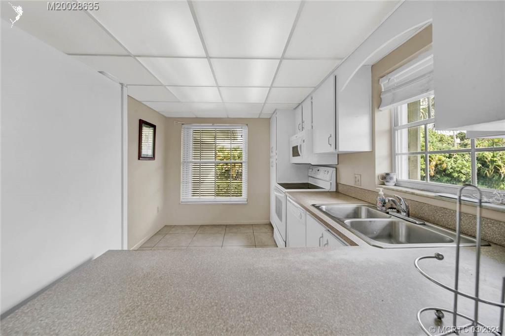 1860 Southwest Palm City Road, Unit 201 Stuart, FL 34994 - Photo 23 of 45 a kitchen that has a sink cabinets counter space and a window