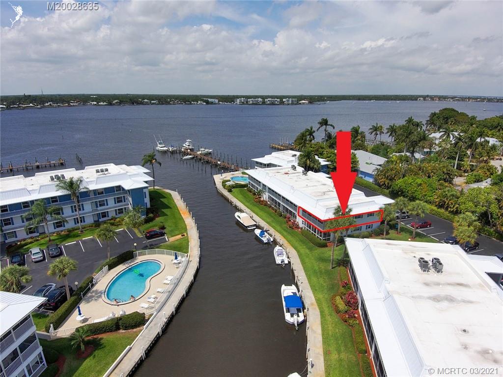 1860 Southwest Palm City Road, Unit 201 Stuart, FL 34994 - Photo 5 of 45 a view of a lake with a table and chairs