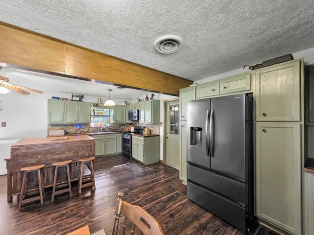 a kitchen with refrigerator and chairs
