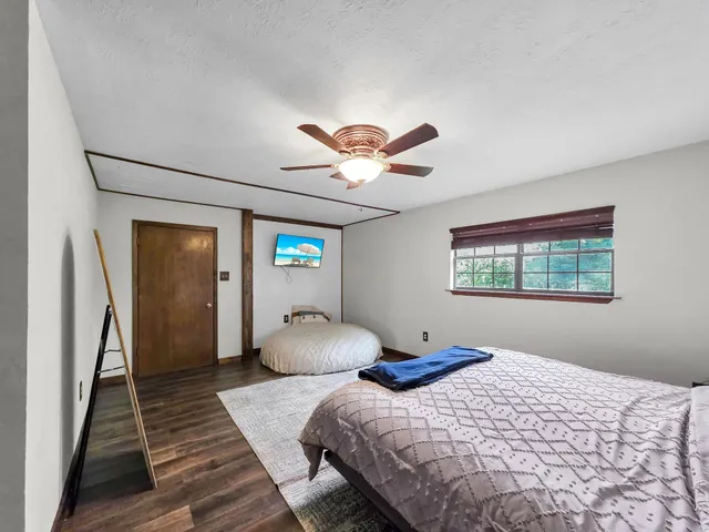 a bedroom with bed and a large window