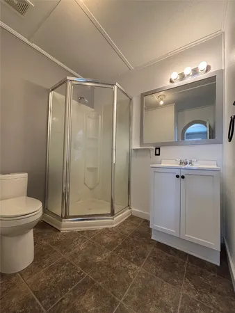 a bathroom with a granite countertop sink mirror vanity and toilet