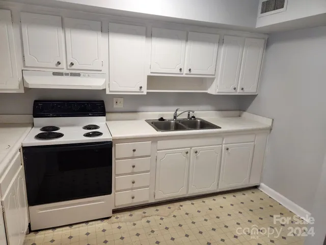 a kitchen with a sink stove and cabinets