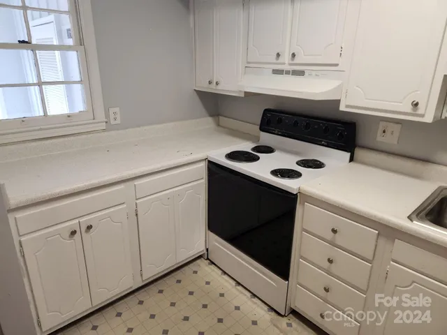 a stove top oven sitting inside of a kitchen