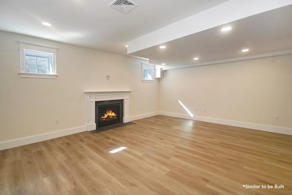 54 Maple Street Concord, MA 01742 - Photo 20 of 27 a view of empty room with wooden floor and fireplace